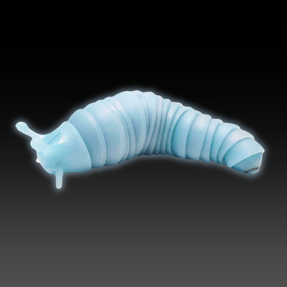 A light blue Super Sensory Glow-in-the-Dark Fidget Slug glowing in the dark.