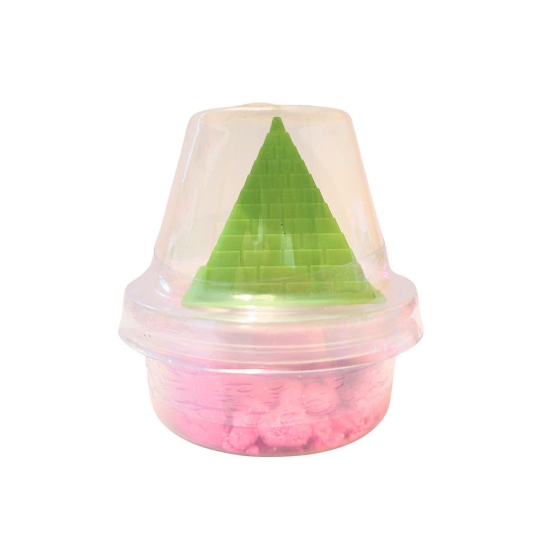 A container of pink sensory sand with a green pyramid castle mold.