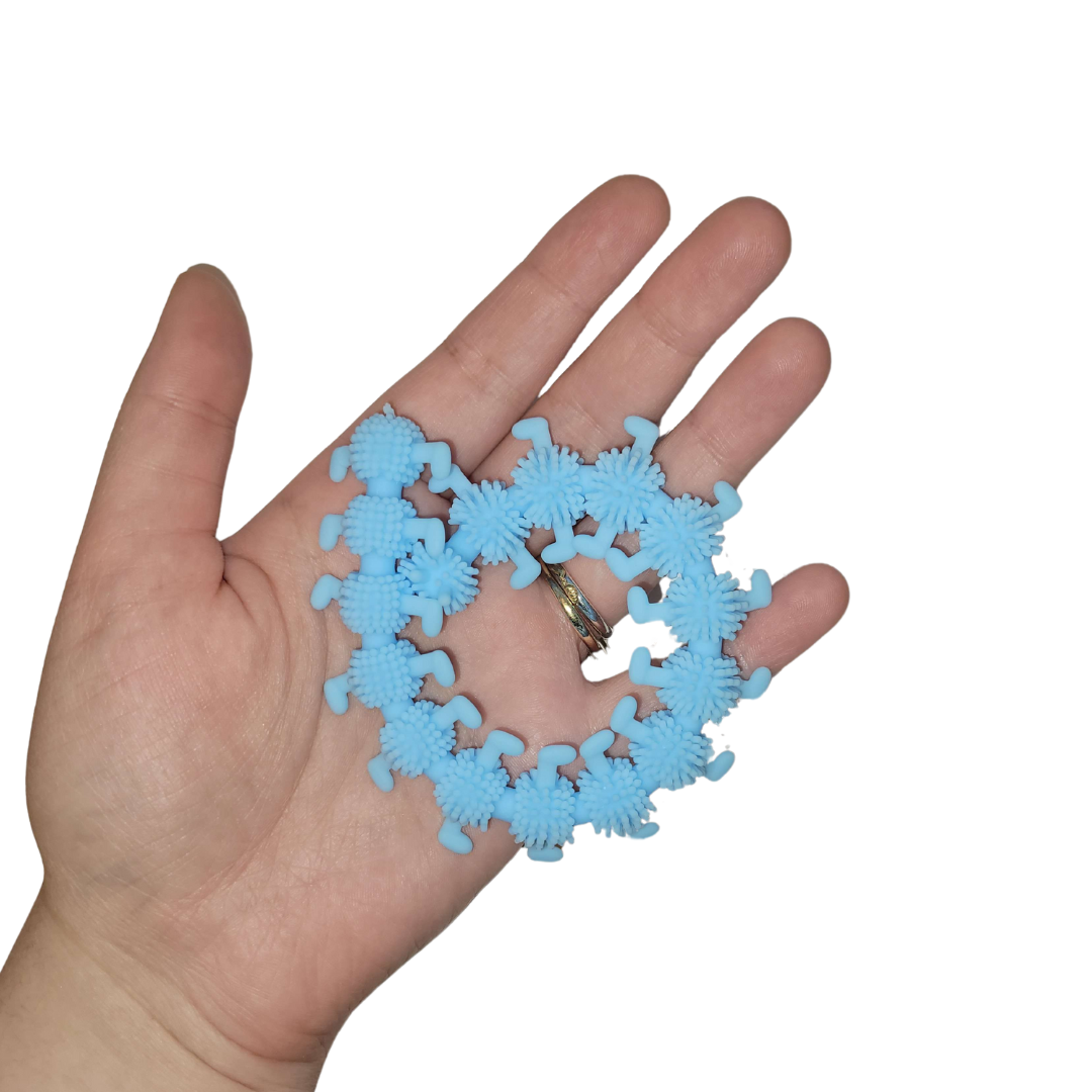 A person's hand holds out a light blue stretchy caterpillar.