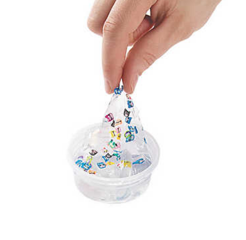 A person's hand stretching clear slime with animal friends out of the container.