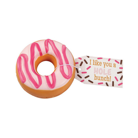 A donut slow rise squishy. The squishy has white icing and pink stripes. Tag reads: "I like you a hole bunch!" 