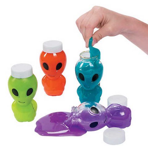 Four containers of alien slime. From left to right, they are lime green, orange, teal, and purple. A hand stretches blue slime out of the container. The purple container is open and slime leaks out onto the surface.