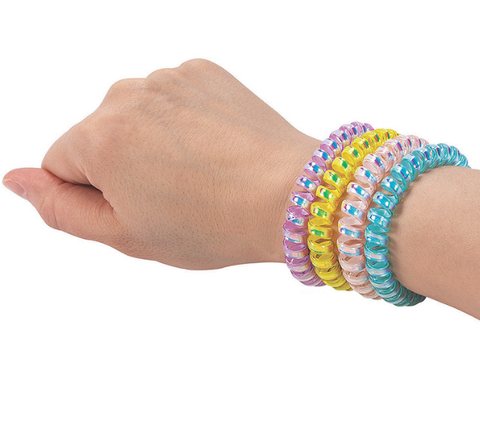 Four iridescent phone cord bracelets on the wrist of a person's hand. From left to right they are purple, yellow, pink, and sky blue.