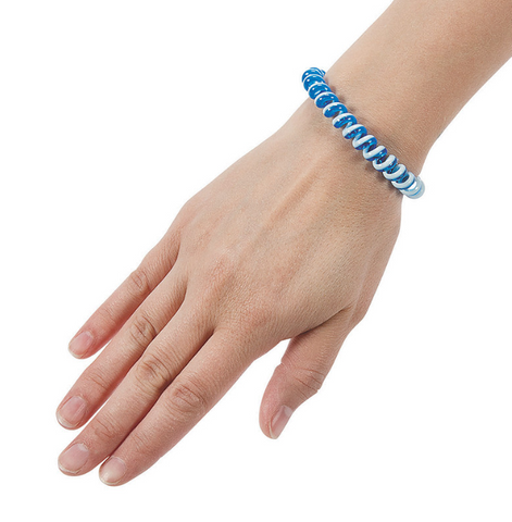A blue and white phone cord bracelet is on the wrist of a person's outstretched hand.